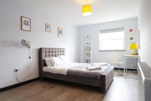 a bedroom with a bed and a desk and a window at The Sunset Apartment - Margate Beach - By Goldex Coastal Breaks in Margate