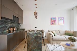 a kitchen and a living room with a couch at Le XV Cannes in Cannes