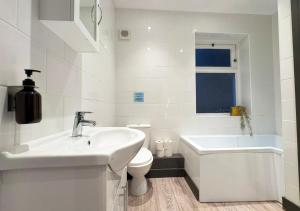 Un baño blanco con lavabo e inodoro. en The Copperfield Apartment - Broadstairs Central - By Goldex Coastal Breaks, en Broadstairs 11 fotos más