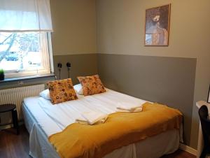 Un dormitorio con una cama con sábanas blancas y una ventana. en Kristinebergs Bed & Breakfast, en Mora