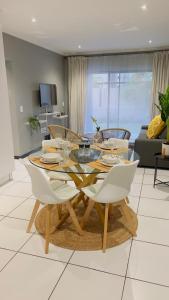 a dining table and chairs in a living room at The Bridge at Ventura Estates in Sandton