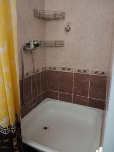 a bath tub with a shower in a bathroom at 2х комнатная квартира в центре in Ustʼ-Kamenogorsk +12 photos