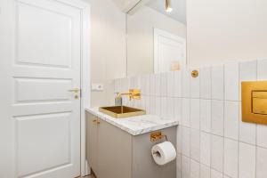 レイキャビクにあるDowntown Baldursbrá - Two Bedroom Apartmentの白いバスルーム(洗面台、トイレットペーパーロール付)