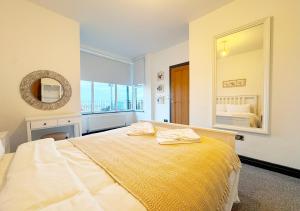 a bedroom with a large bed with a yellow blanket at The Seafront Apartment - Westbrook Bay Beach - By Goldex Coastal Breaks in Kent
