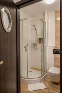 a bathroom with a shower and a toilet at Hotel Dworski Galaktyczny Park in Szczecin