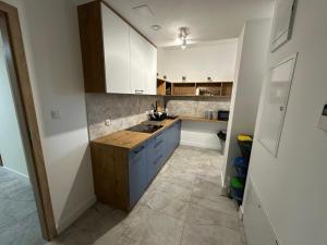 a kitchen with white cabinets and a sink at PrzyStań S7 in Smroków