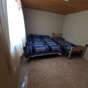 Un dormitorio con dos camas y una ventana. en Hospedaje la flaca, en Gobernador Gregores