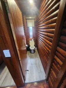a bathroom with a toilet in a room with wooden walls at Plettenberg, a Forever Resort in Plettenberg Bay
