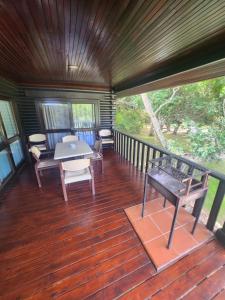 a screened in porch with a table and chairs at Plettenberg, a Forever Resort in Plettenberg Bay