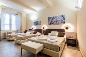 フィレンツェにあるLa Repubblica Suitesのベッド2台とソファがあるホテルの部屋