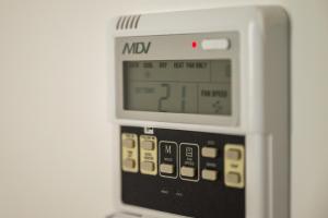 a microwave oven with a digital clock on it at Hotel Dworski Galaktyczny Park in Szczecin