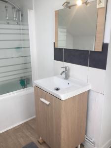 a bathroom with a sink and a mirror at Appart Hotel Le Victor Hugo Art Mechanical et sa pizza offerte in Aurillac