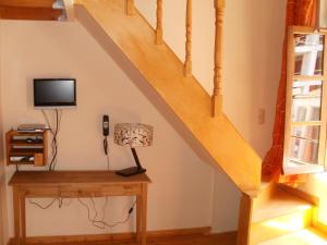 a room with a desk and a staircase with a television at Irene Maisonettes in Chania