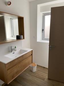 a bathroom with a sink and a mirror at LES INSOLITES DE SOPHIE in Boisgervilly