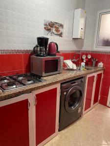 a kitchen with a microwave and a washing machine at Martil in Martil