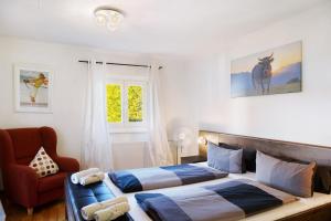 a bedroom with two beds and a chair at Alpen Lodge in Garmisch-Partenkirchen
