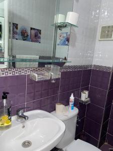 a bathroom with a sink and a toilet and a mirror at Martil in Martil