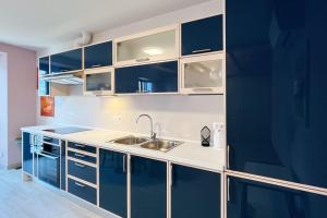 a kitchen with blue cabinets and a sink at Gio House - Affitti Brevi Italia in Onno