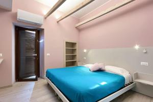 a bedroom with a blue bed in a white room at Gio House - Affitti Brevi Italia in Onno