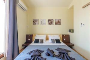a bedroom with a bed with blue sheets and pillows at Thrapsano House with Private Pool for Families by Hospi Living in Heraklion +38 photos