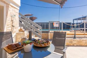 a table with a plate of food on a balcony at Thrapsano House with Private Pool for Families by Hospi Living in Heraklion