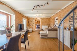 a living room with a stone wall and a table and chairs at Thrapsano House with Private Pool for Families by Hospi Living in Heraklion