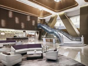 a lobby with a staircase and a couch and chairs at Langham Place Guangzhou - Walking distance to Canton Fair in Guangzhou