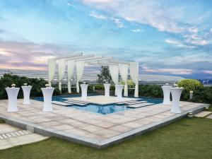 an outdoor wedding ceremony with a white arch and a pool at Langham Place Guangzhou - Walking distance to Canton Fair in Guangzhou
