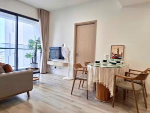 a living room with a table and chairs and a television at EcoVinhomes Grand Park in Long Bình