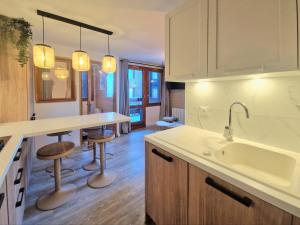 La Plagne TarentaiseにあるLe Nuage - 2050 Belle Plagne, F2 Ski aux piedsのキッチン(シンク、カウンター、スツール付)