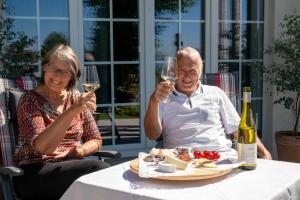 a man and woman sitting at a table with wine glasses at Gersbach-1922 in Schopfheim