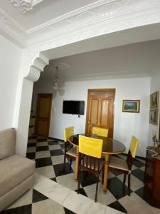 a living room with a table and yellow chairs at High quality appartement (4éme étage) in Martil