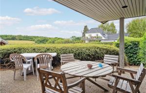 a wooden table and chairs on a patio at Lovely Home In Hesselager With Wifi in Hesselager +18 photos