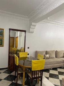 a living room with a table and yellow chairs at High quality appartement (4éme étage) in Martil