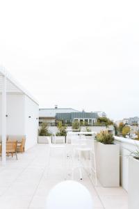 a white balcony with white chairs and tables at Bikube Coliving Hôtel - Lyon Centre Lumière in Lyon