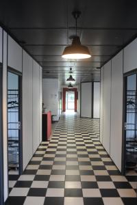 an empty hallway in an office building with a checkered floor at Hebergements le Camp d'Auneau - Le Clos du Camp in Auneau