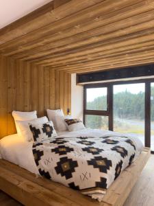 una camera con un grande letto e un soffitto in legno di Grand Hôtel L'ermitage a Font-Romeu