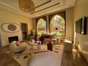 a living room with white furniture and large windows at Villa Ania in Marrakesh