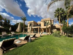 a large house with a swimming pool and a yard at Villa Ania in Marrakesh