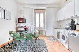 a kitchen with a table and green chairs at Le Nid Carnot - Cocon T4 au Cœur de la Ville in Angers +8 photos