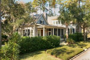 a white house with palm trees and bushes at 2 Bedroom Wilson Village Home 53 in Bluffton