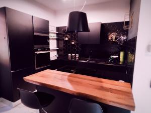 a kitchen with a wooden table and black cabinets at Il quattro e l'otto in Rome