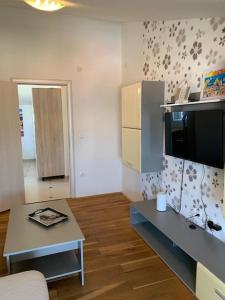 a small living room with a table and a kitchen at Grey Beach Apartment in Stara Novalja