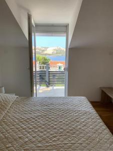 a bedroom with a bed with a view of the ocean at Grey Beach Apartment in Stara Novalja +37 photos
