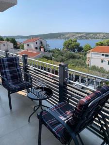 two chairs and a table on a balcony with a view at Grey Beach Apartment in Stara Novalja