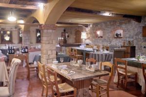 jadalnia ze stołami i krzesłami oraz kamienną ścianą w obiekcie Ai Cadelach Hotel Giulia w mieście Revine Lago