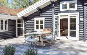 a wooden house with a table and chairs on a patio at 4 Bedroom Awesome Home In Hornbæk in Hornbæk +14 photos