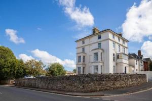 a large white house with a stone wall at Ryde view Studio in Isle of Wight