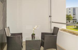 a table with chairs and a table with a vase at Apartment Ndr Strandvej H-504 in Helsingør