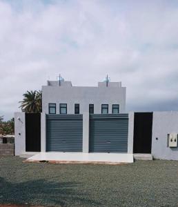 a white building with two garage doors on it at لوقانو فيلا Lugano Villa in Hail